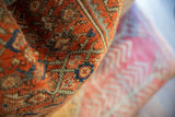 Hand-knotted pile of the vintage Persian rug fragment in rust coral, seafoam, and blue.