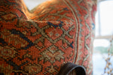 Hand-knotted vintage Persian rug fragment pillow with rust coral and muted green pattern.