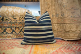 Woven texture and varied indigo blue stripes of the African textile pillow.