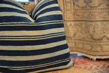 Close-up of the Indigo African Textile Throw Pillow, showing its varying blue and off-white stripes.