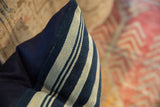 Textured indigo and light striped vintage African textile fragment meets solid navy backing.