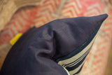 Crisp edge of an Indigo African textile pillow, showcasing navy fabric and stripes.