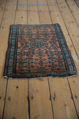 An angled view of the fine Farahan Sarouk rug's overall floral design and deep indigo border.