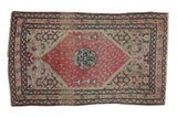 Antique Persian Senneh rug with a red boteh-filled medallion on an ivory field with Herati motifs.