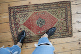 Antique Senneh collector rug with a red medallion, showcasing its size and finely knotted texture.