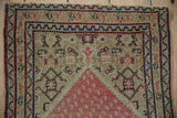 Tattered end and original side selvage on an antique Senneh rug with even wear.