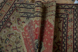 Fine, low pile of an antique Persian Senneh rug showing time-softened saffron and red details.