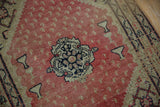 Antique Senneh rug's floral medallion, hookah motifs, and boteh-covered red field.