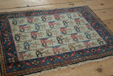 Angled view of a vintage Persian bagface highlighting its pictorial field and tattered fringe.