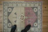 Distressed vintage Anatolian rug, dusty raspberry abrash, starburst and plant motifs.