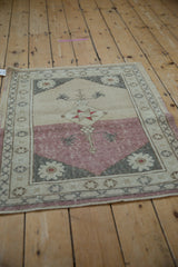 Anatolian rug corner showing hard color change from ivory to dusty raspberry, plant motifs, and wear.