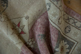 Distressed vintage Anatolian rug, showcasing its dusty raspberry and ivory field color change.