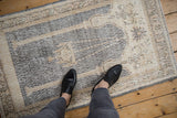 Overhead view of a distressed Sparta rug showing decorative wear and texture in denim and ivory tones.
