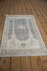 Vintage distressed Sparta prayer rug from a high angle, showing its column design in faded tones.