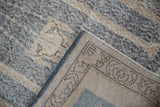 View of the distressed rug's reverse, showing the hand-knotted weave and original side cord.