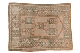 Distressed vintage Melas rug with geometric prayer design in dusty rose, seafoam, and bronze.