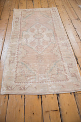 Vintage distressed Oushak runner side with faded floral border and serrated guls.