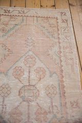 Worn pale rose and ivory geometric border on a vintage Oushak runner.