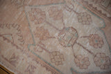 Distressed Oushak rug runner close-up with faded dusty rose guls and visible foundation.