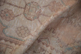 Distressed vintage Oushak rug pile with worn texture, faded ivory, dusty rose, and subtle green patterns.