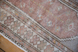 Vintage Distressed Oushak rug's intact original side cord selvage and worn antique ivory and dusty mauve pile.
