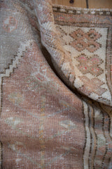 Distressed Oushak rug texture with soft mauve, antique ivory, and subtle silver tones.