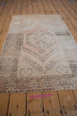 Vintage Distressed Oushak rug showing heavy abrashes on dusty rose geometric floral border.