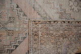 Distressed Oushak rug, dusty rose geometric pile texture, and visible hand-knotted reverse.