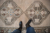 Distressed geometric medallions in oxidized silver, pale denim blue, and chestnut hues.