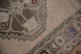 Distressed vintage Oushak runner with geometric patterns in ivory, silver, and pale blue.