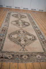 Vintage Oushak runner's fringed end, low pile displaying time-softened ivory, silver, blue motifs.