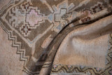 Close-up of distressed vintage Oushak rug showing geometric patterns and varied pile height.