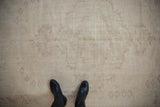 Distressed vintage Oushak rug with wear across knot heads and faded patterns.