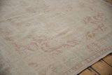 Distressed vintage Oushak carpet pile showing wear, faded raspberry and pale sage patterns.