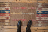 Distressed Oushak runner pile details camel field, red finned blossoms, blue water column patterns.