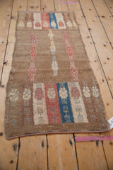 Textured detail of distressed vintage Oushak runner in camel, raspberry, and sapphire tones.