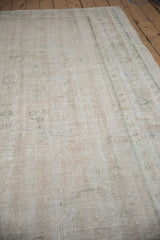 Worn texture of the distressed Oushak rug, revealing soft ivory, platinum, and olive hues.