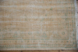 Detail of vintage Oushak carpet, showcasing distressed texture and mint green motifs.