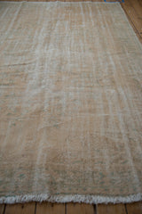 Distressed Oushak rug texture showing worn knot heads and muted cream, sea foam green.