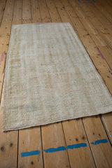 Distressed texture of vintage Oushak runner, showcasing exposed foundation, cream, and olive green hues.