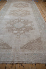 Vintage Distressed Oushak rug runner, showing primitive geometric starburst motifs on abrashed beige field.