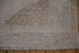 Distressed Oushak runner pile, showing even wear and pale geometric border design.