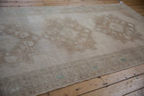 Vintage distressed Oushak runner's border with muted beige and subtle green patterns.