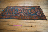 Corner of vintage Persian Mehreban rug, displaying madder root border and sky blue medallion.