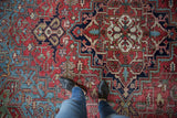 Vintage Heriz rug with stepped diamond and palmette motifs in brick red and navy.