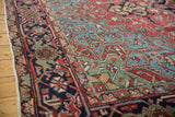 Persian Heriz rug corner with triple-tier spandrel, geometric vinery, brick red, and navy.