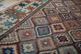 Antique Caucasian runner's geometric diamond field with nuanced details and crab gul border.