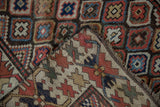 Antique Caucasian runner's visible knot heads, hand-knotted foundation, and pile detail.