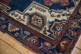 Persian Hamadan rug, geometric floral motifs in navy, rust, ivory, and blush, with even visible wear.