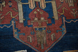 Detail of vintage Hamadan rug's geometric floral finial, navy, rust, tan, showing even wear.